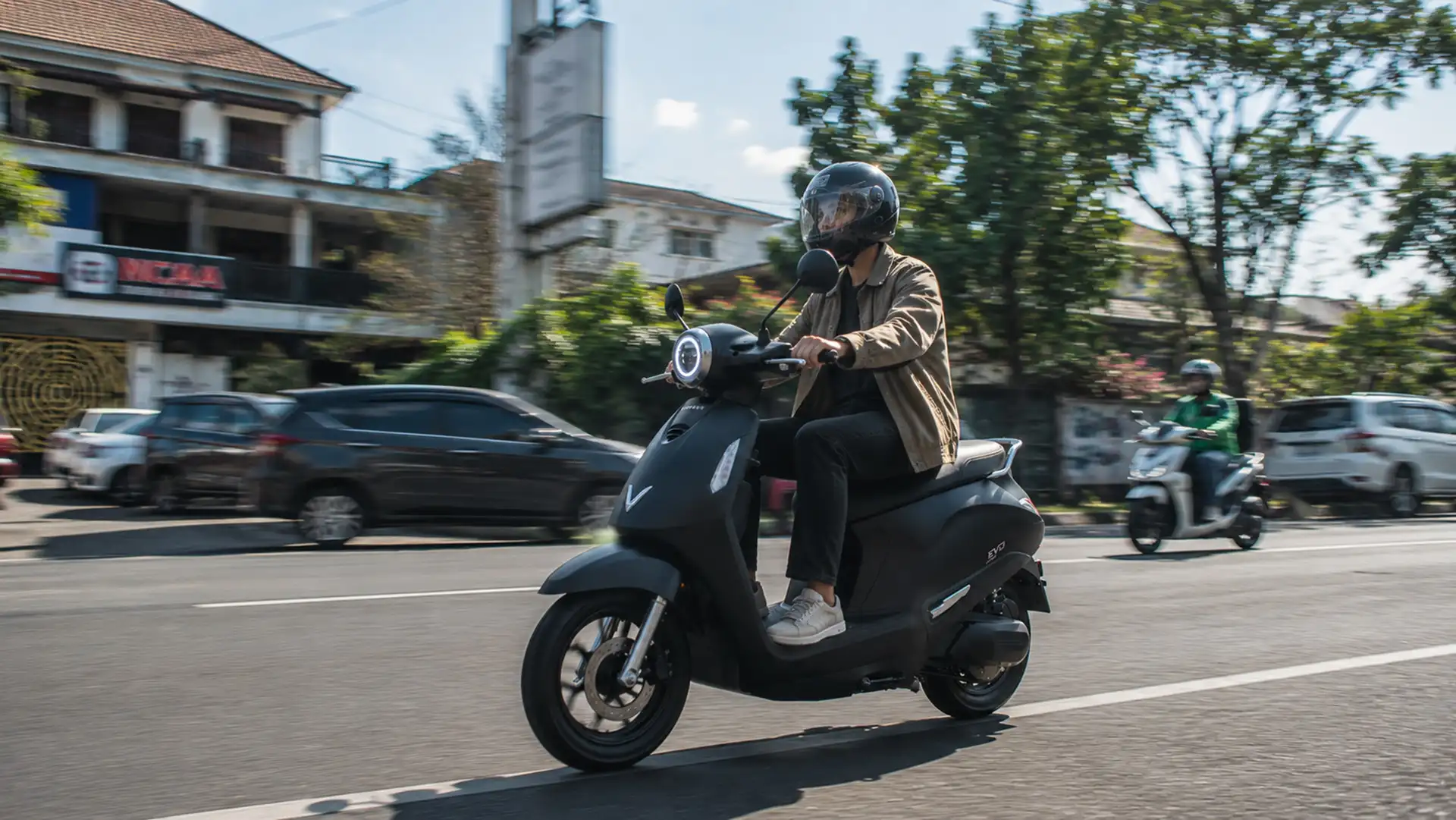 VinFast Evo melaju di jalanan kota dengan pengendara mengenakan helm